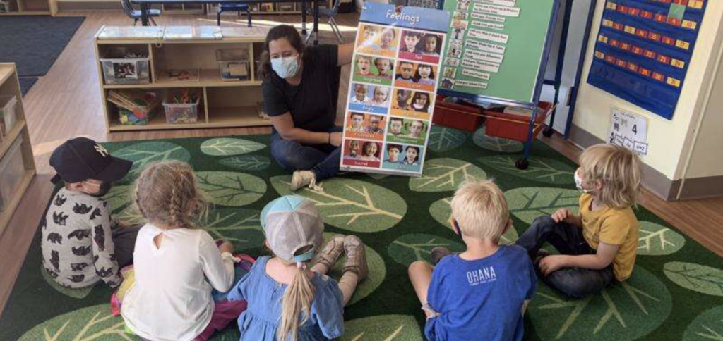 Teacher and young kids in a preschool classroom